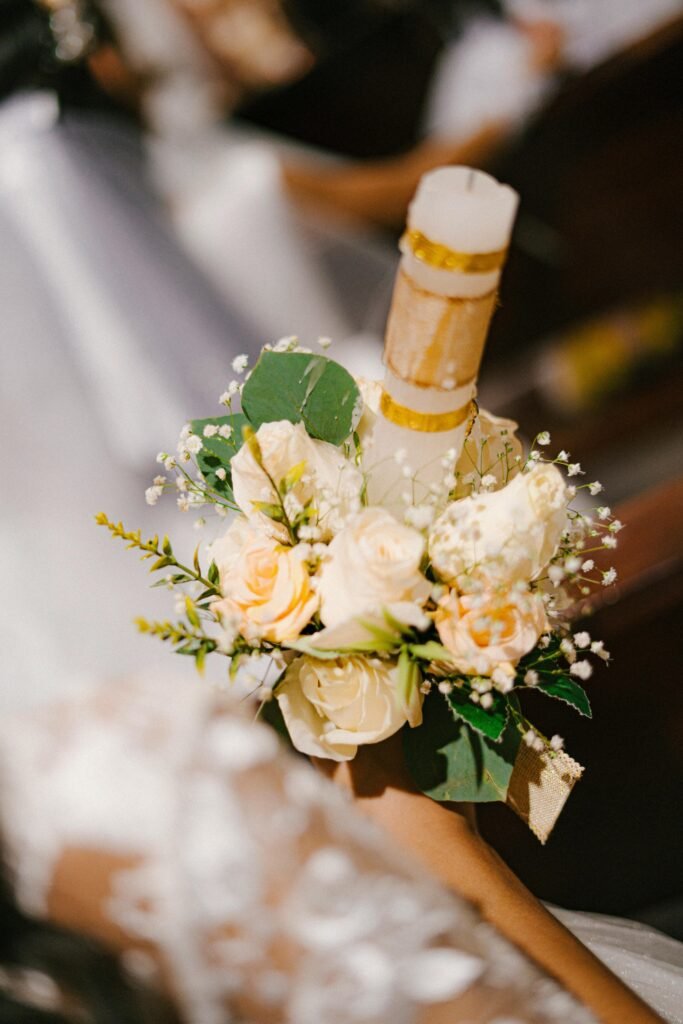 Close-up of a delicate bouquet with a candle at a communion ceremony.
